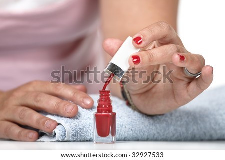 Woman putting on nail polish on finger nails