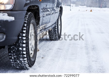 Close up of a cars tires on a snowy road