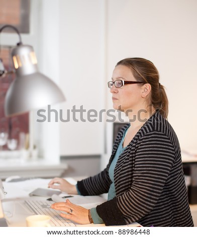 Woman in front of computer working with hands on keyboard. She is very concentrated. Focus is shallow.