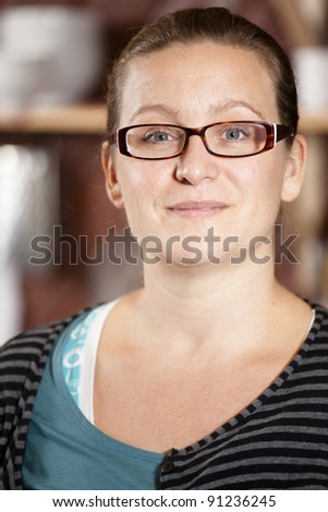 Portrait of a cute, casual woman looking into camera smiling.