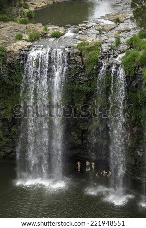 DORRIGO NATIONAL PARK, AUSTRALIA - 2 JAN, 2014: Unidentified young tourists swim under the Dangar Falls, close to the town of Dorrigo in New South Wales.  The National Park is world heritage listed.