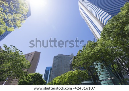 Ultra-wide angle looking up Tokyo blue sky fresh green skyscrapers