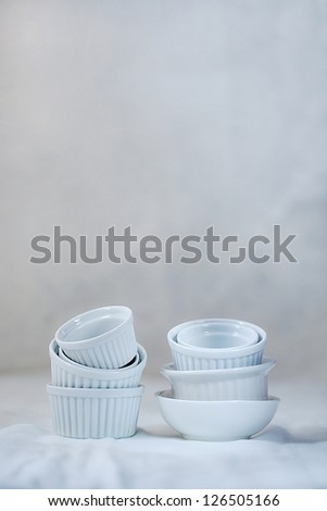 Sets of mini white bowls for food prep on white background
