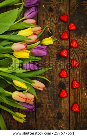 bouquet of tulips and candy on a table, selective focus, the darkened background