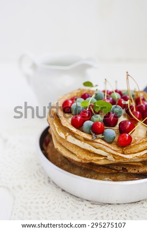 pancakes and berries in a frying pan on a table