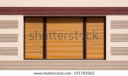Closed window with brown wooden shutters