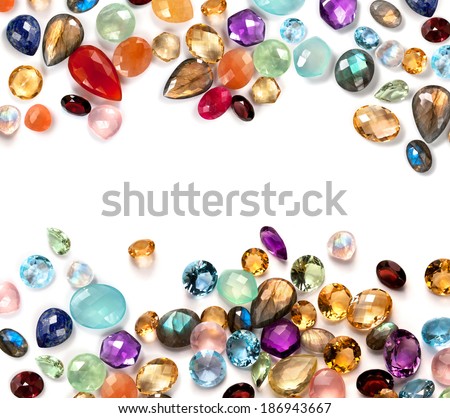 Colorful gems on white background. Many real polished stones: amethyst, sapphire, blue topaz, rainbow moonstone, labradorite, ruby, chalcedony, lapis lazuli, aventurine, peridot, rose quartz, citrine.