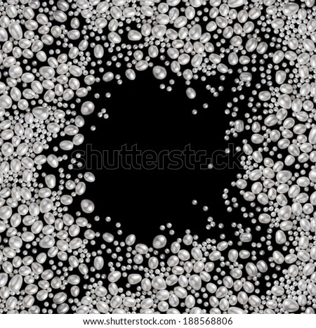 Pearls on black background. Many white pearls with empty space in the middle.