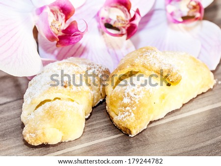 close up of sweet bread rolls on rustic wood desk with orchids