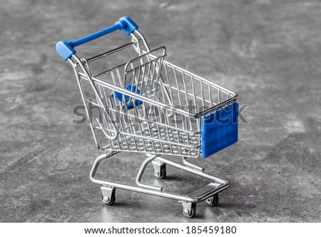 close up of blue chrome shopping cart on dark floor
