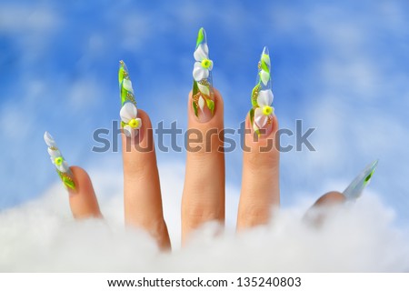 Female hand with floral design on nails.