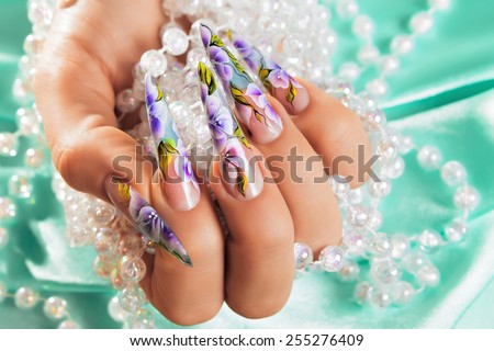 Female hand with  beautiful floral design on  nails.