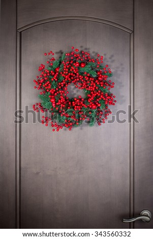 Holly berry christmas wreath on wooden door