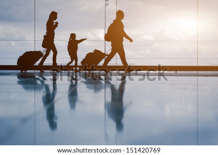 Silhouette Of Young Family With Luggage Walking At Airport, Girl Showing Something Through The Window