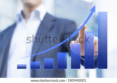 Business consultant presenting a blue chart about growing markets with office buildings in background