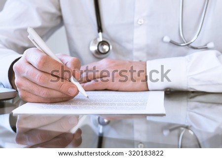 Male doctor writing medical prescription or certificate