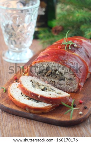 meat loaf with mushroom stuffing wrapped in bacon on the table with Christmas decorations