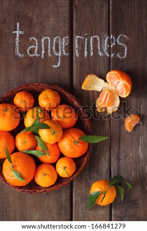 tangerines with leaflets on a brown background, inscription \