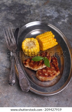 grilled meat with a side of corn