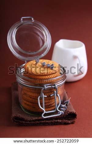 cookies in a glass jar with a sprig of lavender