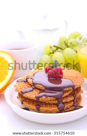 Weekend breakfast: waffles with chocolate and raspberries, grapes, tea and orange juice