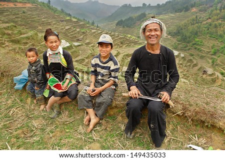 GUIZHOU, CHINA - APRIL 10: Ethnic Minorities in China, Miao black family on the background of the mountain landscape in the rice terraces in the spring, April 10, 2010. Basha Village, Congjiang County