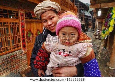 GUIZHOU PROVINCE, CHINA - APRIL 13: Rural family of Southeast Asia, father holds child in her arms, April 13, 2010. Zengchong Dong ethnic minority  Village, Guizhou Province, SouthWest China.
