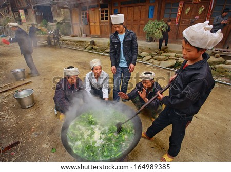 GUIZHOU PROVINCE, CHINA - APRIL 12: Chinese villagers, peasants, farmers cook soup in a big pot, outdoors, April 12, 2010. Asia, Rural Chinese cook pottage,  Dong people minority, Zengchong village.