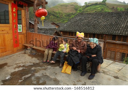 PINGAN VILLAGE, GUANGSI PROVINCE, CHINA - APRIL 5: East Asia, the mountain village of China\'s ethnic minorities, farmhouses peasants farmers, villagers resting on the bench,  April 5, 2010.