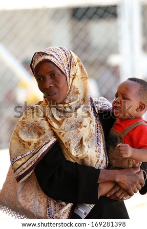 ZANZIBAR, TANZANIA - FEBRUARY 16: Tanzanian woman with her head covered with a large patterned handkerchief, holding in her arms, a child and a half years, February 16, 2008.