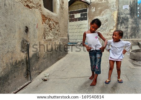 ZANZIBAR, TANZANIA - FEBRUARY 16:  The island of Zanzibar, Stone Town, narrow street, two small dark-skinned girl, 4-6 years old, playing outdoors, February 16, 2008. Stone Town in Zanzibar.