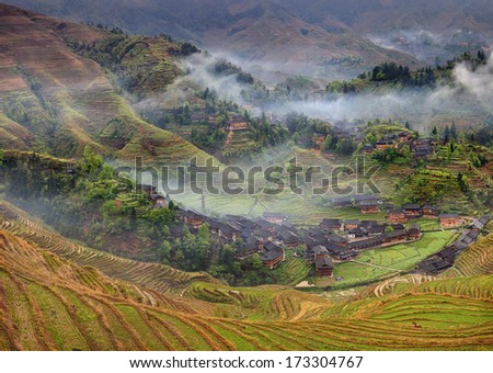 Longsheng, near Guilin, Guangxi Province, China. Spring landscape with village and rice terraces, mountain rural China. Peasant village in mountainous region of China agricultural, rural landscape.