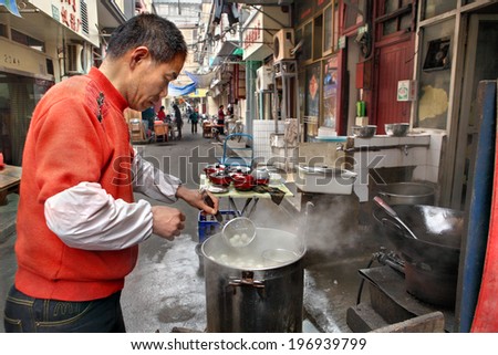 Shanghai, China - April 20, 2010: Seller street food, outdoor, cooking dumplings in a big pot
