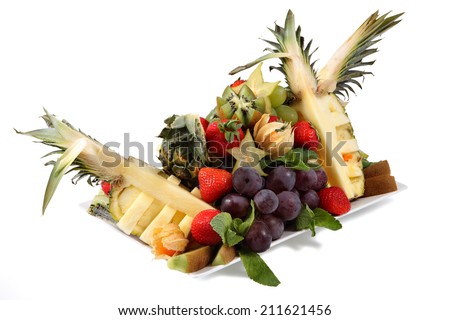 Fruit Mix, a set of exotic fruits, fruit assortment on a white plate, isolated on a white background. Pineapple, strawberries, grapes, kiwi.