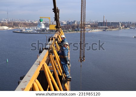 St. Petersburg, Russia - October 30, 2014: High-altitude installation work working console tower crane. High-altitude installation work Installer is working at height, erection crane.