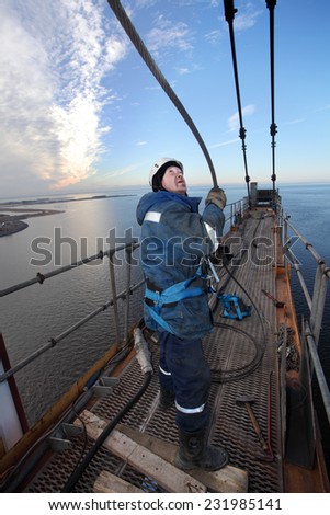 St. Petersburg, Russia - October 30, 2014: Steeplejacking Erector is working at height when installing console section of the tower crane. High-altitude installation work working console tower crane.