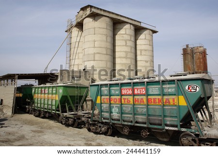 St. Petersburg, Russia - April 27, 2009: Railway wagons for transportation of dry cargo, freight train with car load of cement, wagon collecting cement from silo, goods train depositing cement to silo