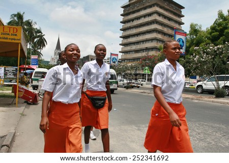 Dar es Salaam, Tanzania - February 21, 2008: Four black african girl in orange skirts and white blouses.