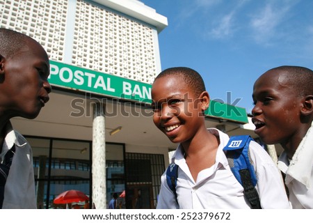 Dar es Salaam, Tanzania - February 21, 2008: Three unidentified African boys older students, chatting in the street, in the city center.