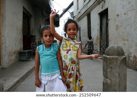 Stone Town,  Zanzibar, Tanzania - February 16, 2008: Two unknown Tanzanian girls 10 years old, standing in the middle of the narrow streets of the old city.