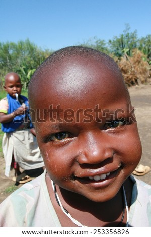 Meserani Snake Park, Arusha, Tanzania - February 14, 2008: Unknown black African girl from the Maasai tribe, about 4 years old, with short hair, and a smile on her face, close-up portrait.