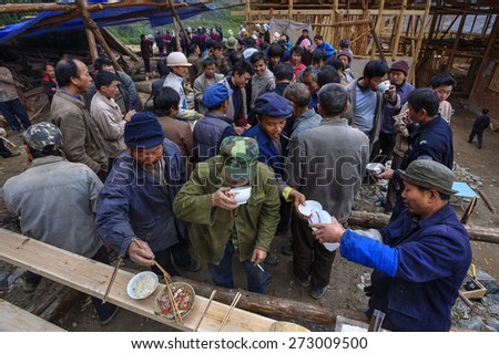 Langde Village, Guizhou, China - April 16, 2010: Crowded rural festivities, villagers drink alcohol and take their food together.