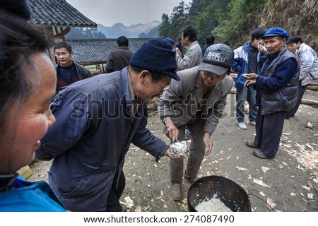 Langde Village, Guizhou, China - April 16, 2010: Rural holiday in the Chinese countryside minority Miao, boiled rice farmer lays in the hands of the guests.
