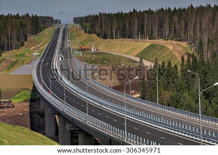 Saint Petersburg, Russia - August 7, 2015: Top view of highway bridge in final stage of construction, and a high-speed road in the forest. Leningrad Region, new motorway in  direction of Sortavala.