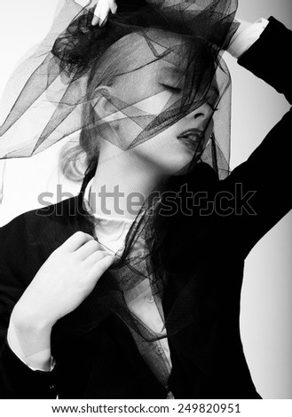 Black and white fashion portrait of a veiled young woman