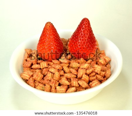 Two strawberries on a bowl of cereal.
