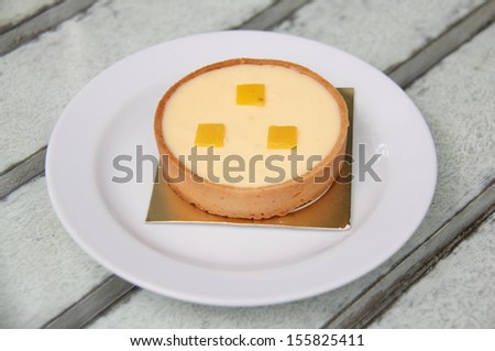 Lemon tart decorate with pieces of lemon skin