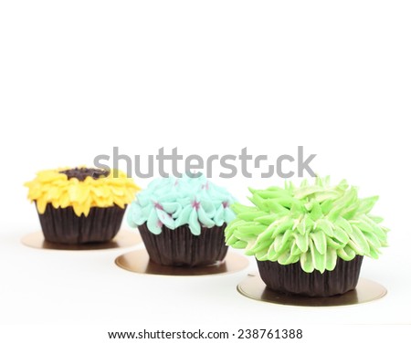 Blue Hydrangea, Green Chrysanthemum, and Yellow Sunflower Chocolate Cupcake isolated on white.