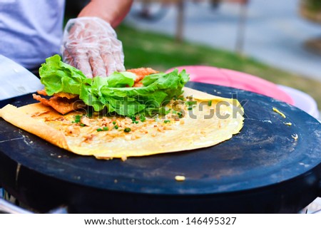 Pancake in China ,a kind of delicious street food,Wrapped with egg sauce, green onion, parsley and lettuce