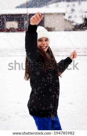 young girl throwing snow ball